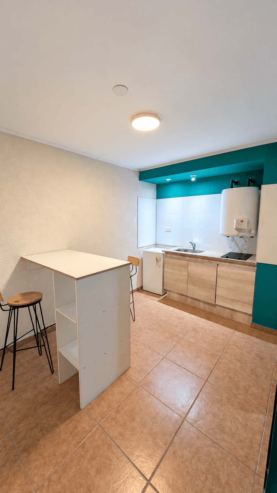 Propuesta visual de kitchenette con anafe eléctrico en un apart de Syrah